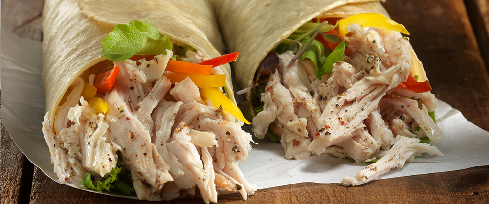 Maple Leaf Piri Piri Pulled chicken wrap with peppers and toppings on wood background