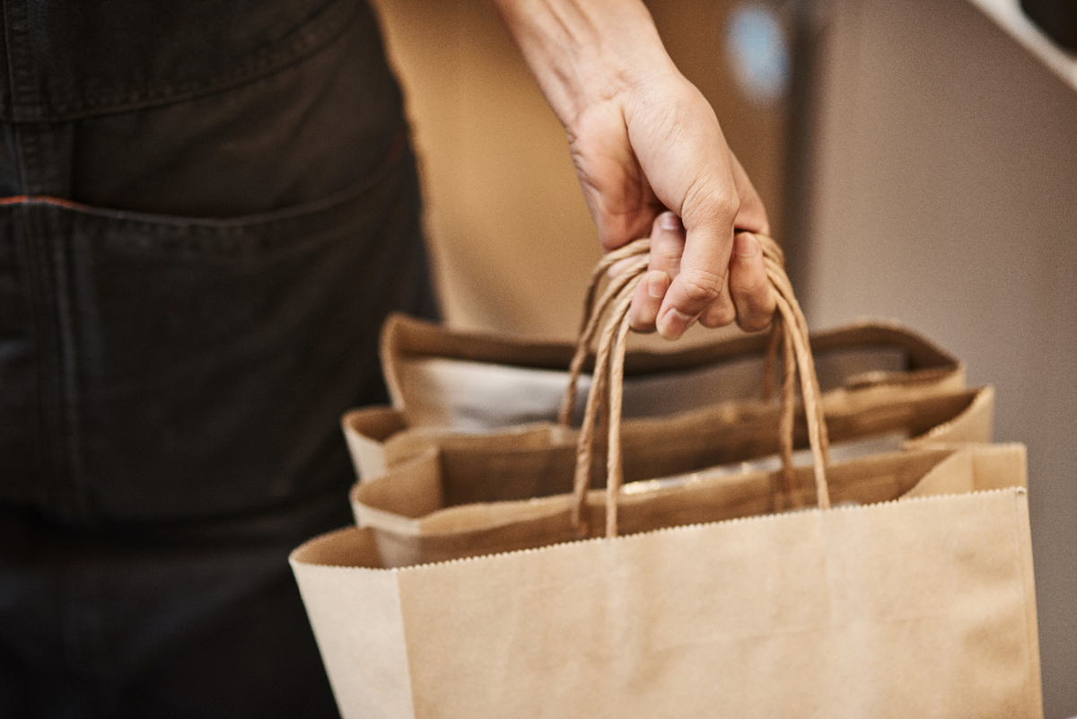 Restaurant server carrying take out bags