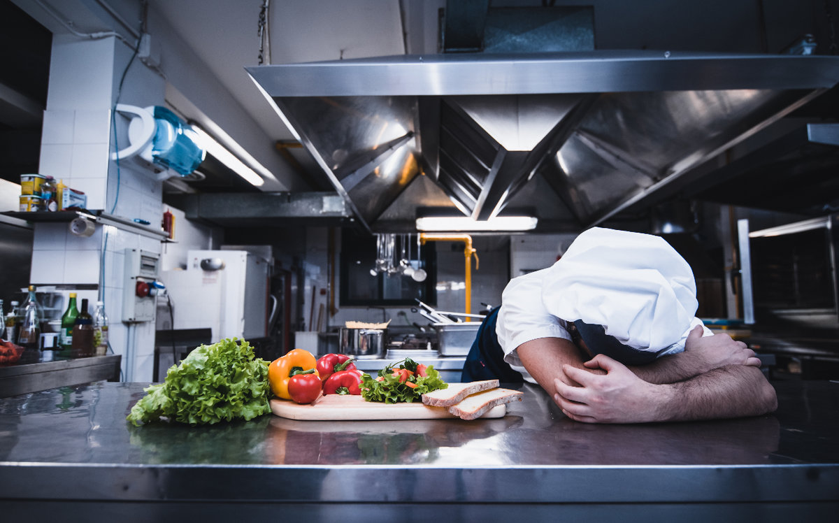 Chef with head down while preparing food