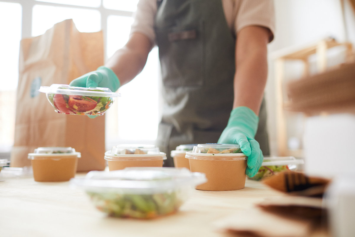 Server packing take out food wearing gloves