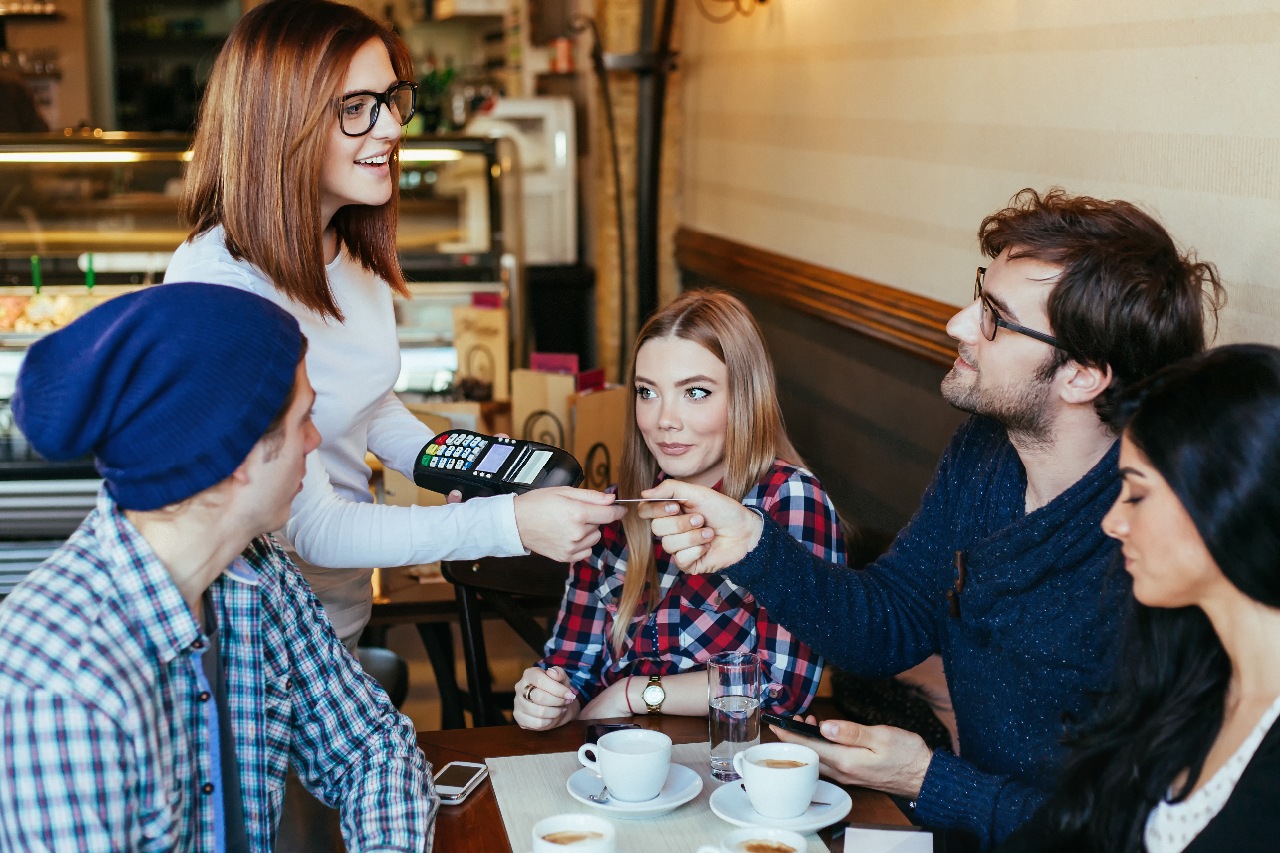 People enjoying coffee in a restaurant and paying for their meal