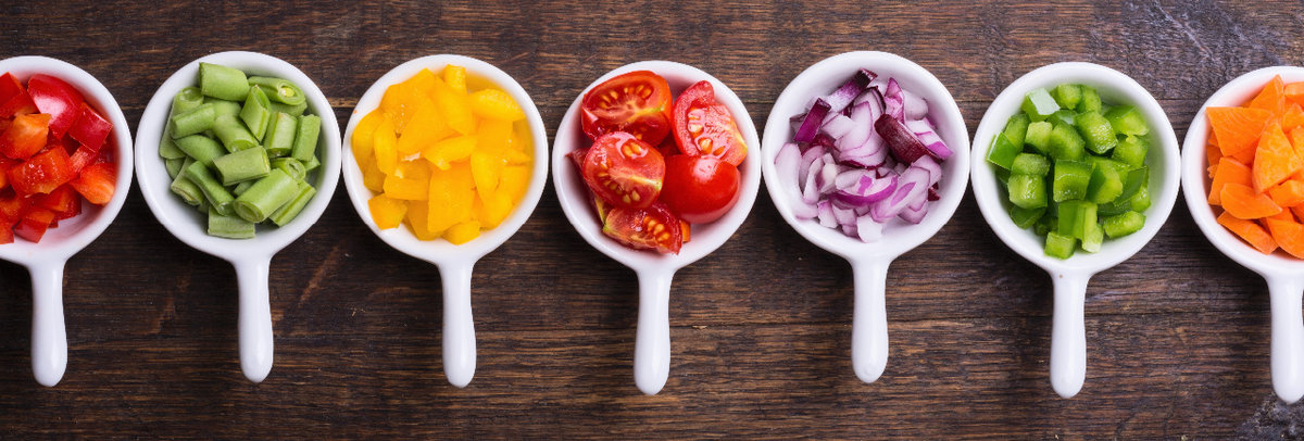 Various vegetables chopped in white bowls