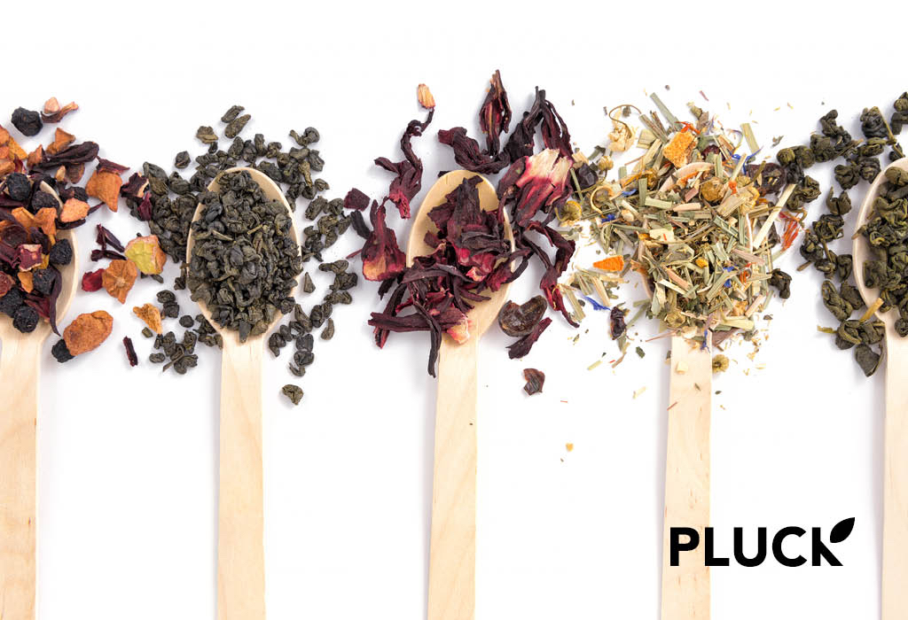 Spoons with herbs and ingredients for tea