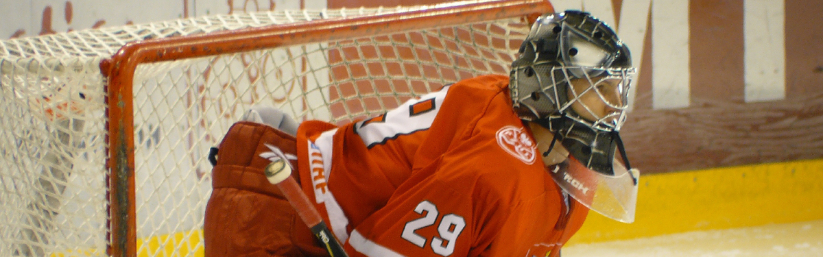 A hockey goalie standing at a hockey net
