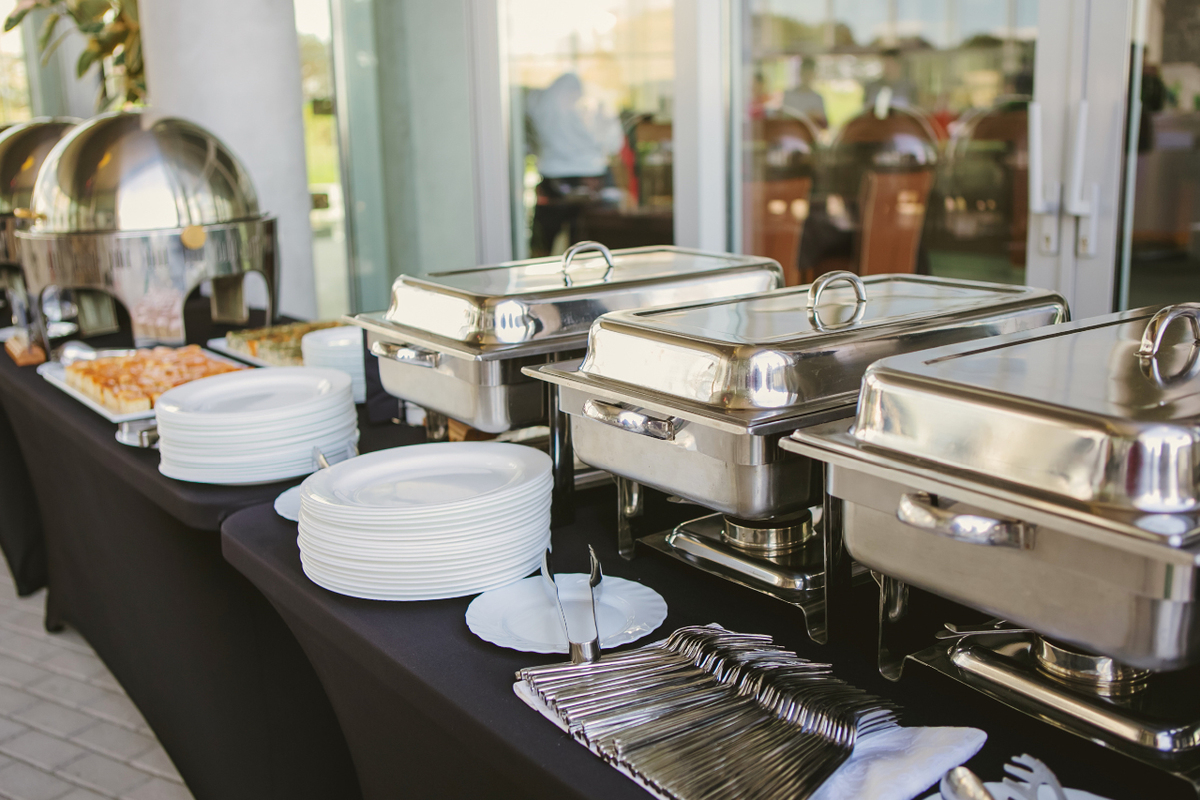 Catering banquet table set up with dishes and warmers